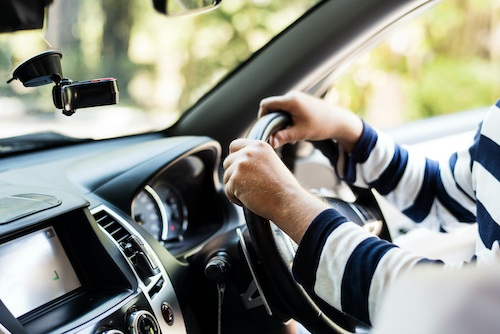 man in striped shirt driving car