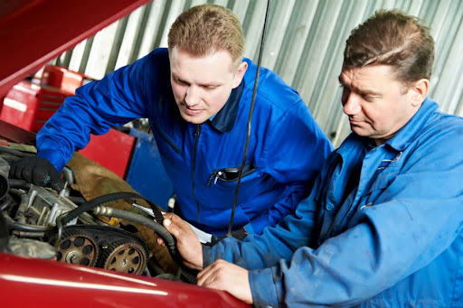auto mechanics inspecting a car engine for issues