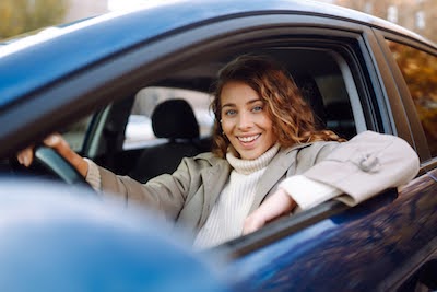 woman smiling in her car after a car repair service